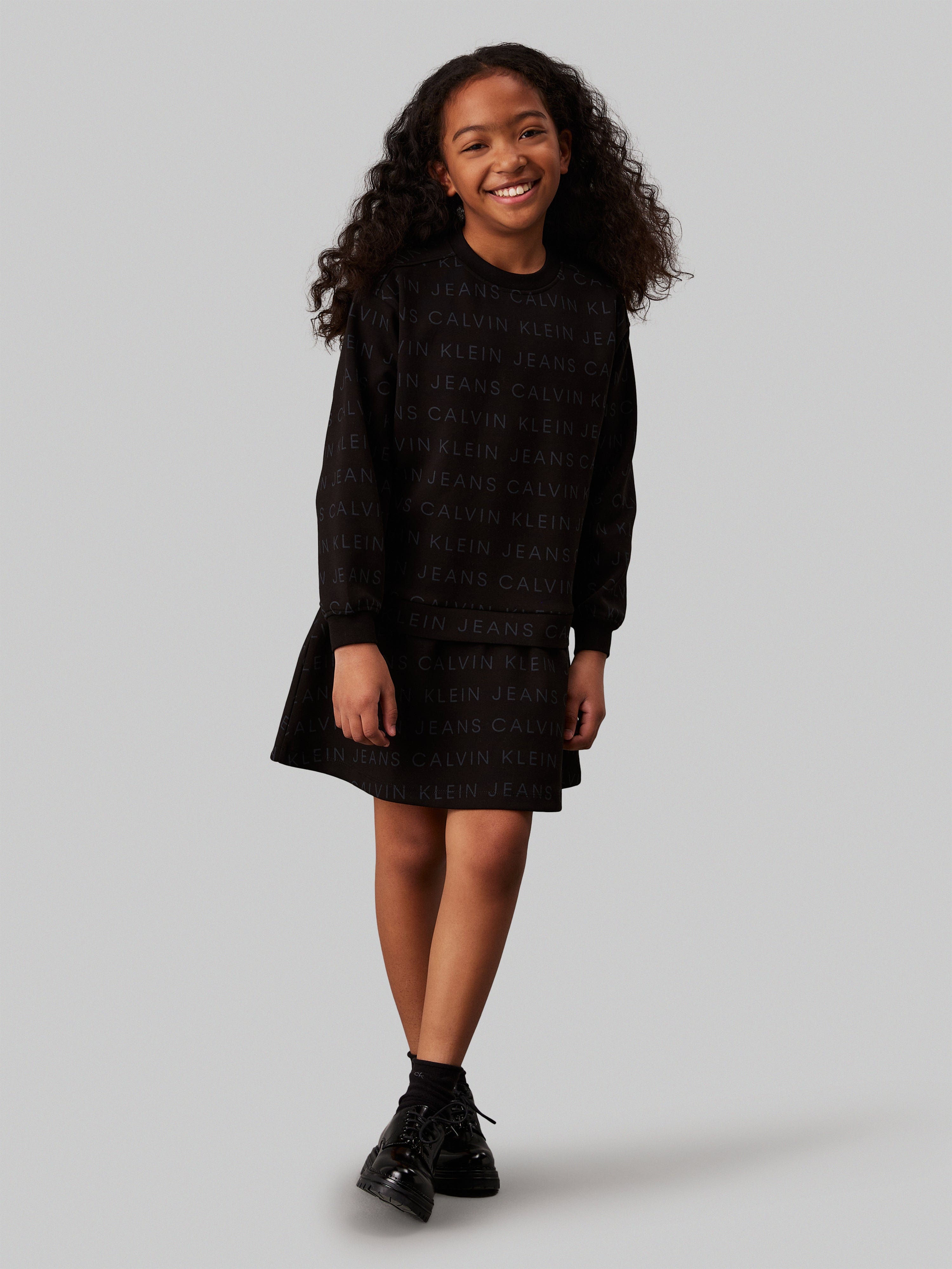 Calvin Klein Girls Logo AOP Fleece Dress in Black Calvin Klein Girls Logo AOP Fleece Dress in Black